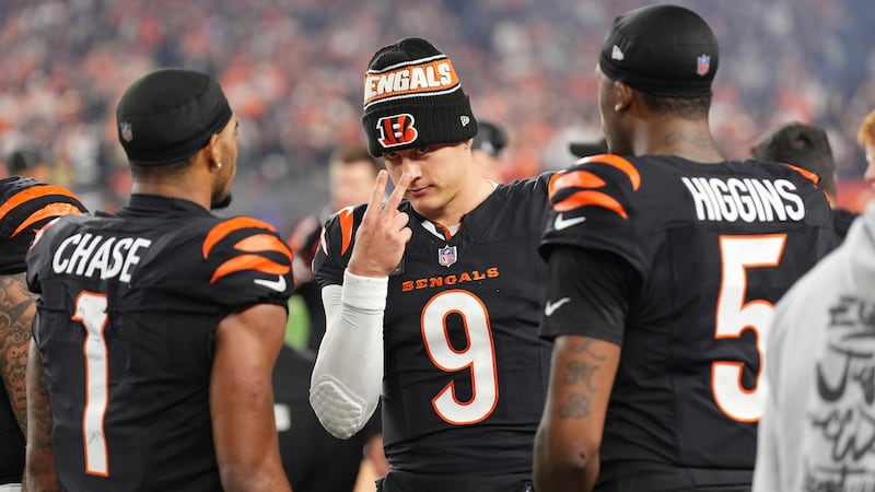 Cincinnati Bengals quarterback Joe Burrow, center, talks with wide receiver Ja'Marr Chase,...